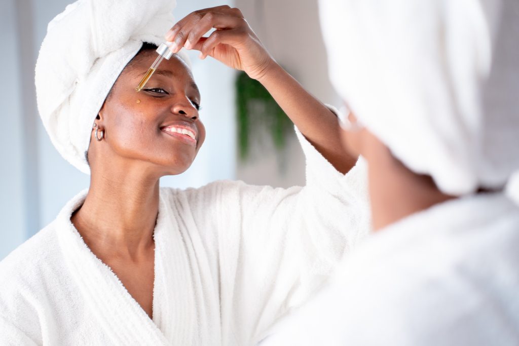 young woman applying serum with rosehip oil to reduce signs of aging
