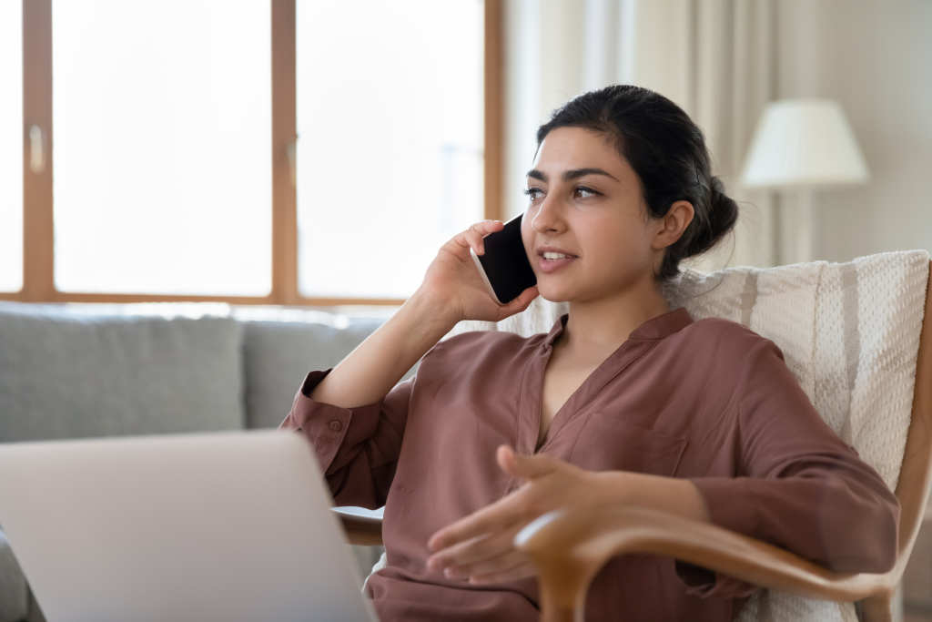 young woman talking in the phone to schedule an appointment with a doctor about how to fix turkey neck