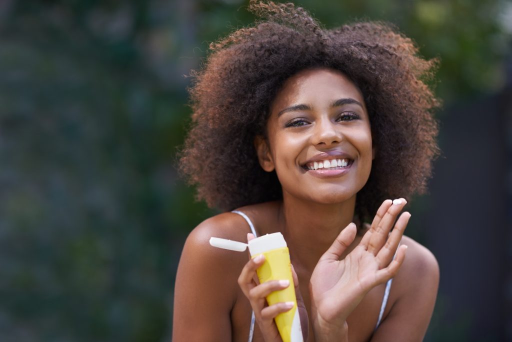 smiling, excited woman before applying the best tinted sunscreen