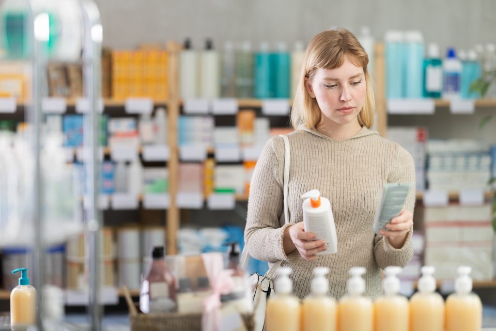 a girl uses a beauty app to quickly choose a skin cream at a drugstore