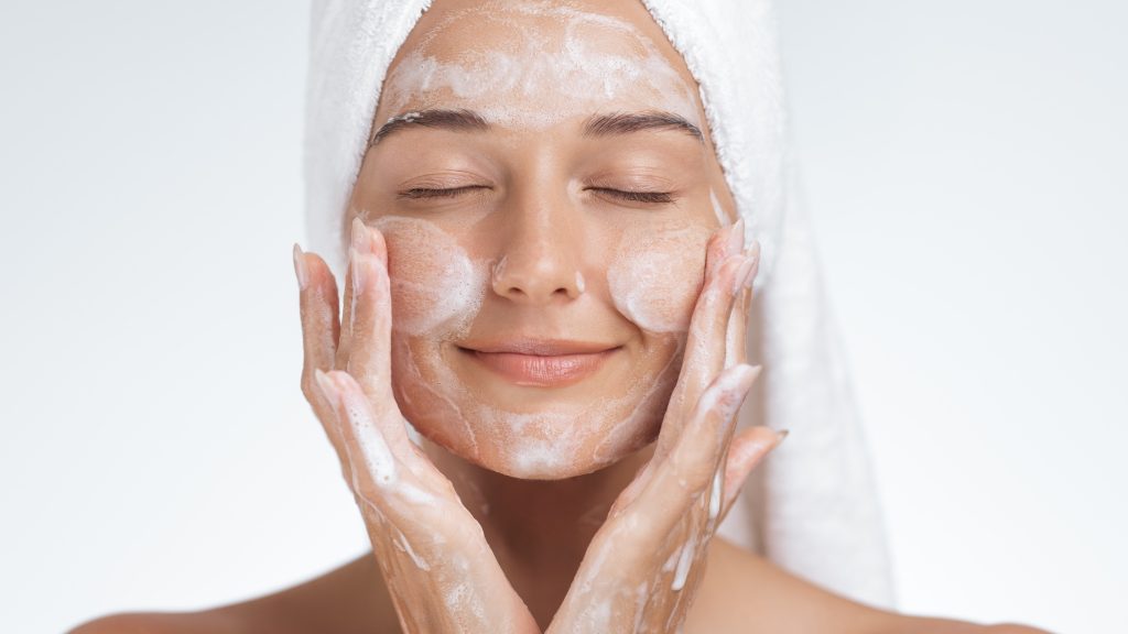 woman washing her face as part of a double-cleansing routine