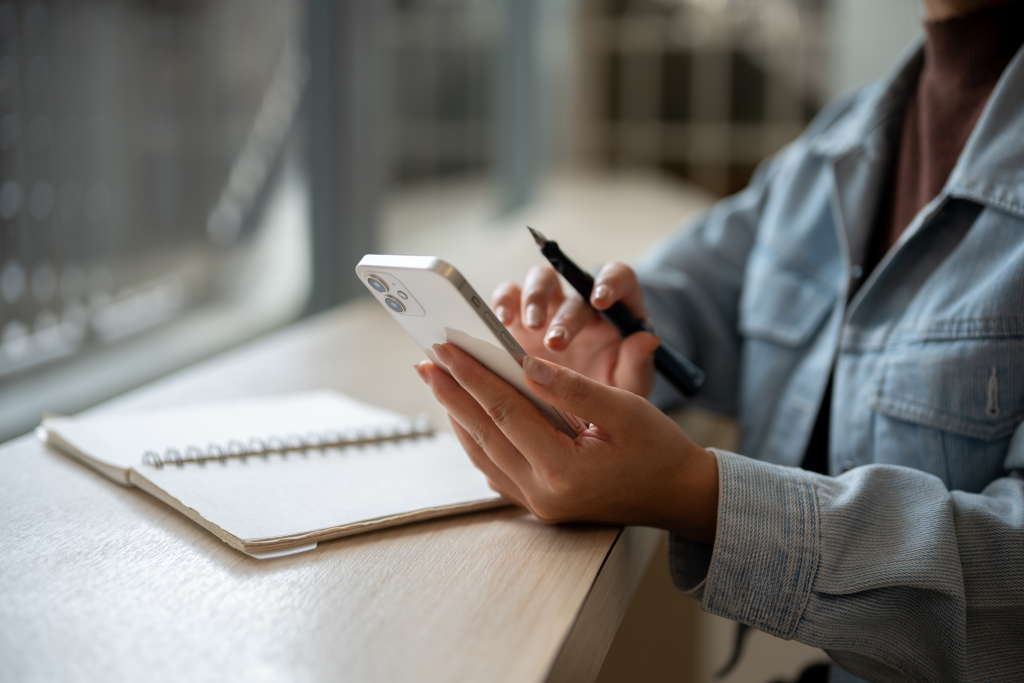 woman journaling using healthy lifestyle apps on phone